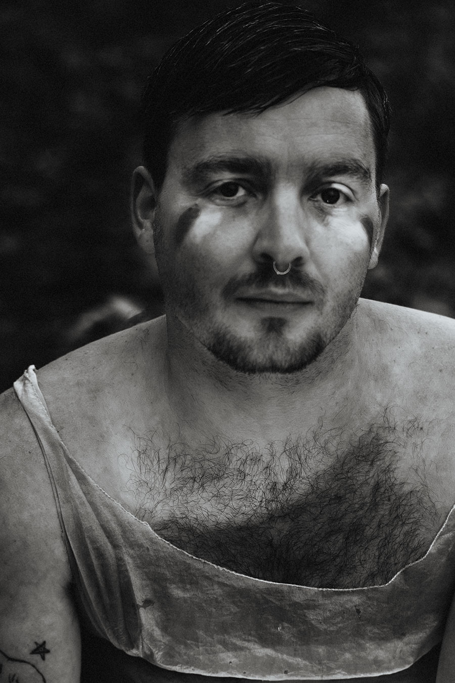 Schwarzweiß-Porträt einer Person mit direktem Blick in die Kamera, konzeptuelle Fine-Art-Fotografie über innere Zustände.