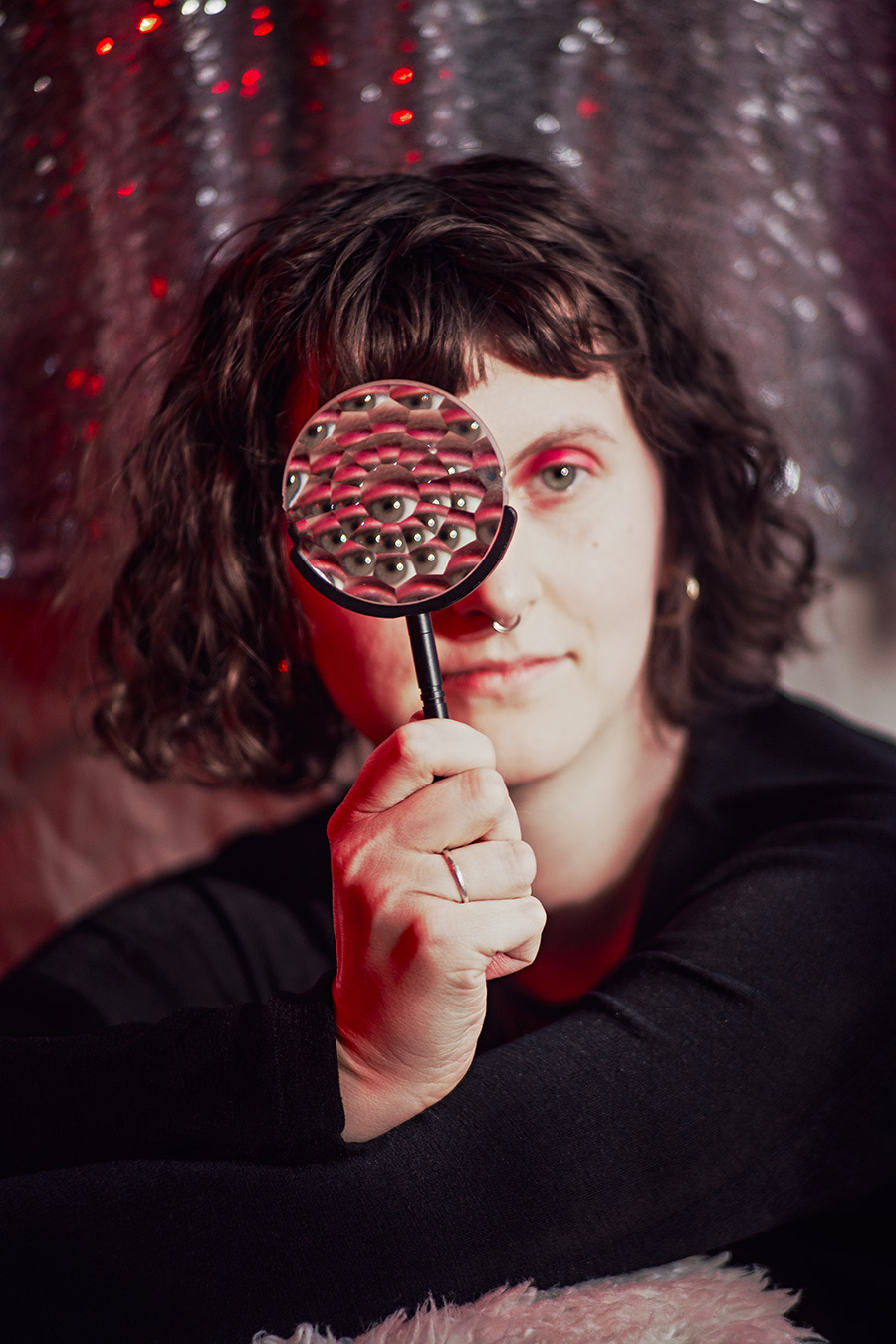 Surreales Porträt in roter Lichtstimmung: vervielfachte Augen überlagern das Gesicht und thematisieren Wahrnehmung, Überforderung und innere Zustände. Fotokunst von Antje Kröger.