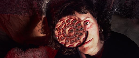 Surreales Porträt mit vielfachen Augen im Rotlicht – Antje Kröger