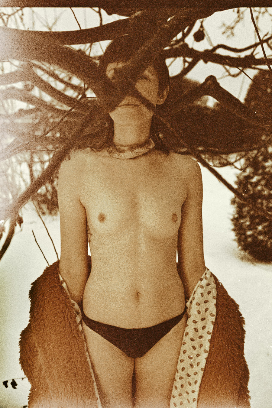 Kunstfotografie Sepia, Frau mit Fell-Mantel im Baum, nostalgisch