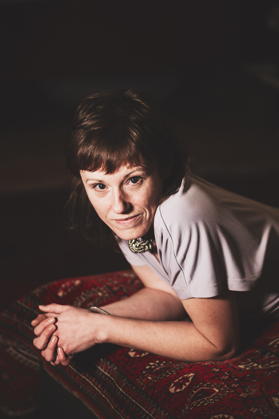 Kunstfotografie Farbe, Frau liegend auf rotem Teppich, atmosphärisch