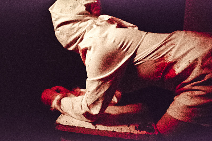 Rote Markierungen auf weißem Kleid in analoger Körperstudie
