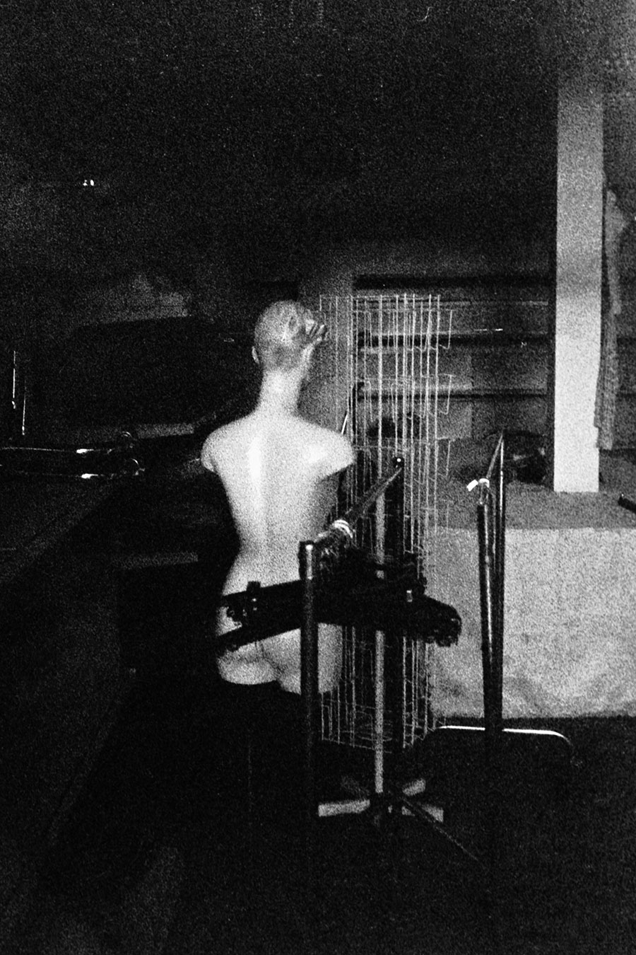 Schwarzweißfoto einer Schaufensterpuppe in dunklem Raum, Kunstfotografie