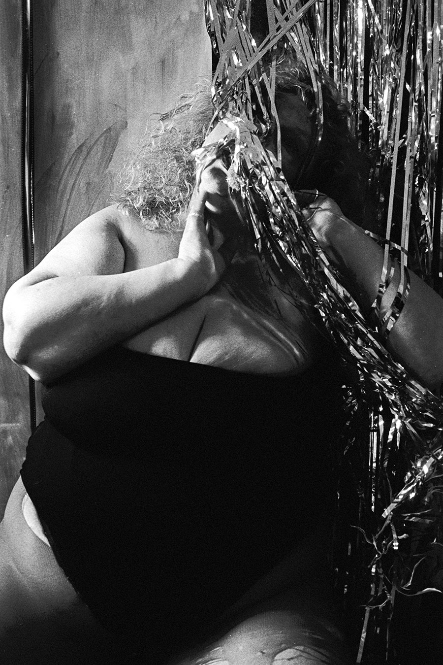 Analoges Selbstporträt müde angelehnt am Lametta-Vorhang, Schwarz-Weiß