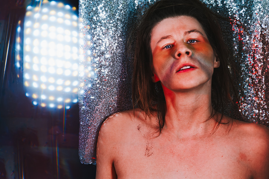  Frau vor Glitzervorhang blickt nach oben, Fotokunst Die Lücke