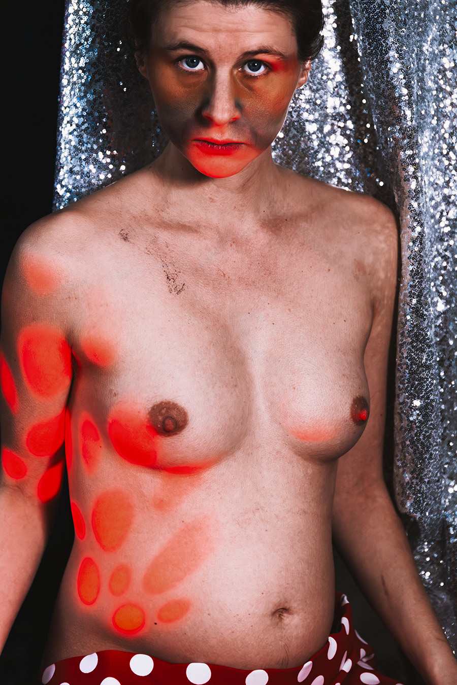 Frontales Porträt mit roten Lichtflecken auf Körper, Fotokunst Die Lücke