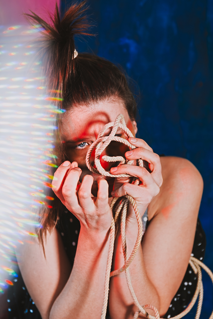 Frau hält verknotetes Seil vors Gesicht, Fotokunst Die Lücke