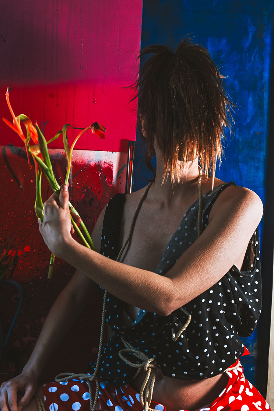 Frau von hinten hält welke Tulpen, Fotokunst Die Lücke