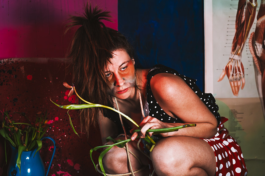 Frau hockt mit welken Tulpen, Fotokunst Die Lücke