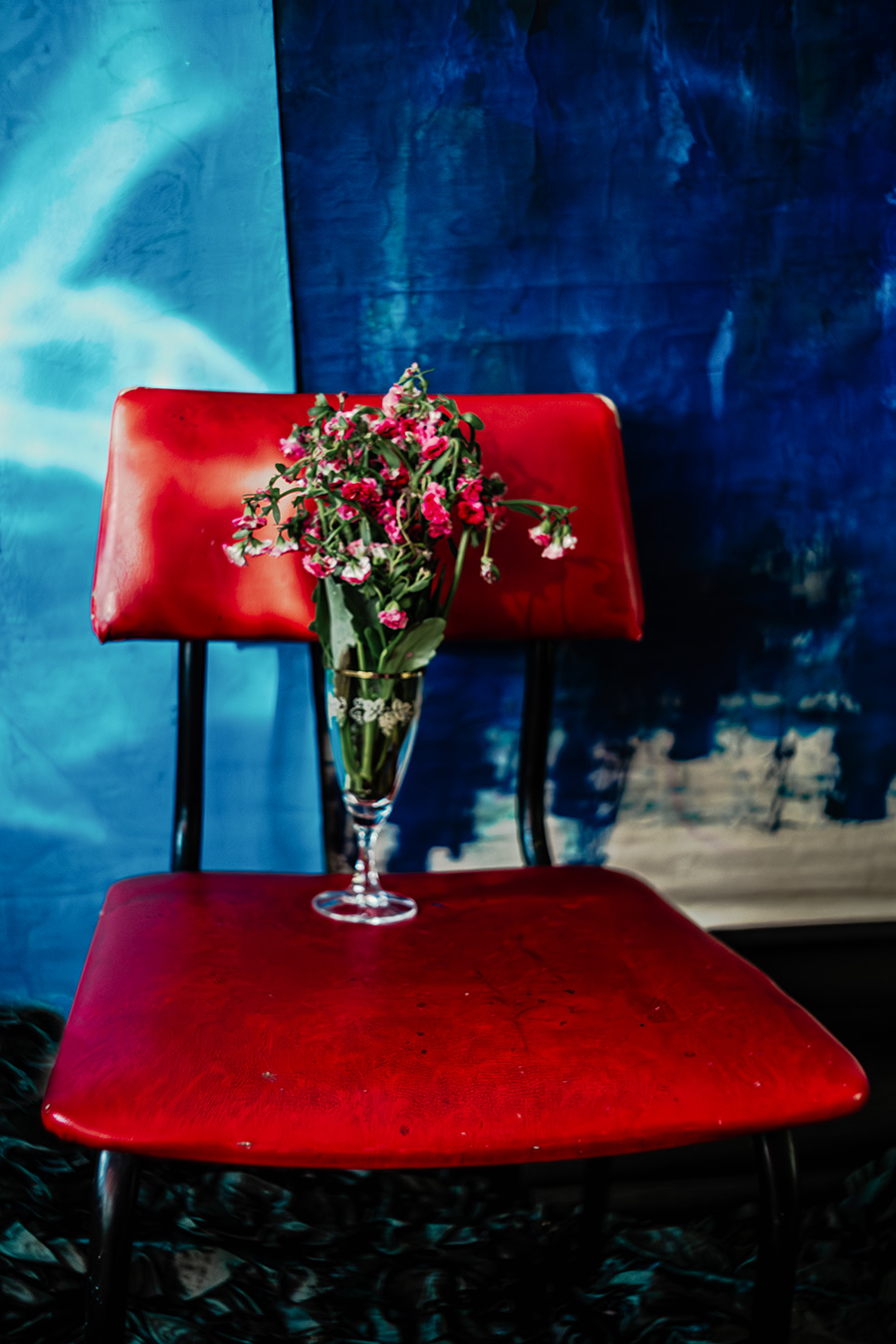 Roter Stuhl mit welken Blumen in Vase, Fotokunst Der Ballast