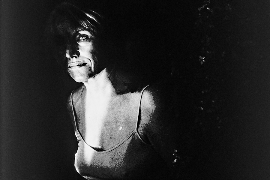 Greisenmädchen Teil 2, Greisin mit dramatischem Seitenlicht und Make-up lächelt in die Dunkelheit, Fomapan 400 Ortho, Fotografin Leipzig