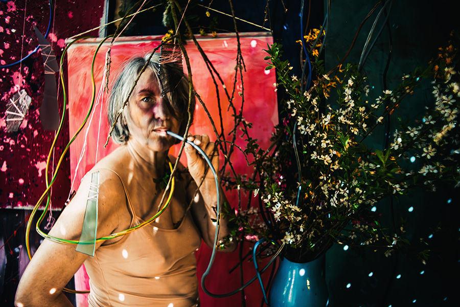 Fotokunst Greisenmädchen, Frau mit Lichtpunkten hält Kabel im Mund, direkter Blick in die Kamera, Fotografin Leipzig