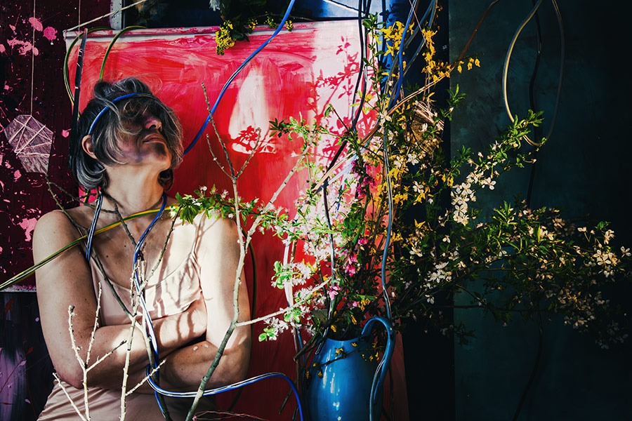 Fotokunst Greisenmädchen, Frau mit zurückgelehntem Kopf und verschränkten Armen zwischen Blütenzweigen, Fotografin Leipzig