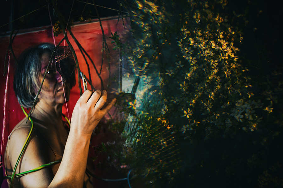 Fotokunst Greisenmädchen, Frau hält Glasscheibe vor sich, goldenes Bokeh aus Blüten im Hintergrund, Fotografin Leipzig