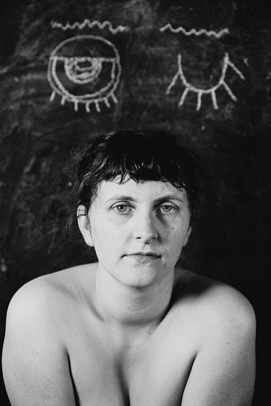 Trachom Fotokunst, klares Nahporträt ohne Lupe mit direktem Blick vor zwei Kreideaugen auf schwarzer Tafel, Fotografin Leipzig, Antje Kröger
