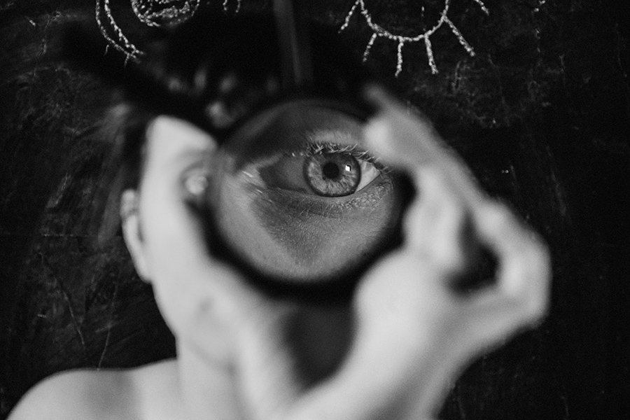 Trachom Fotokunst, extremes Nahbild eines Auges durch eine Lupe vergrößert vor schwarzer Tafel mit Kreideaugen, Fotografin Leipzig