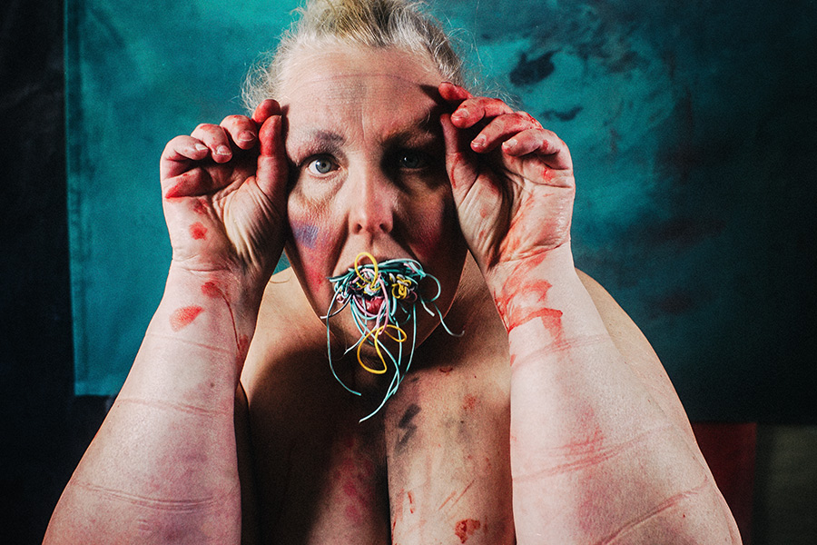 Inszeniertes Selbstporträt mit Gummibändern im Mund, Druckspuren auf der Haut, direkter Blick – Fotokunst Antje Kröger Leipzig Berlin, Serie Mehrenge