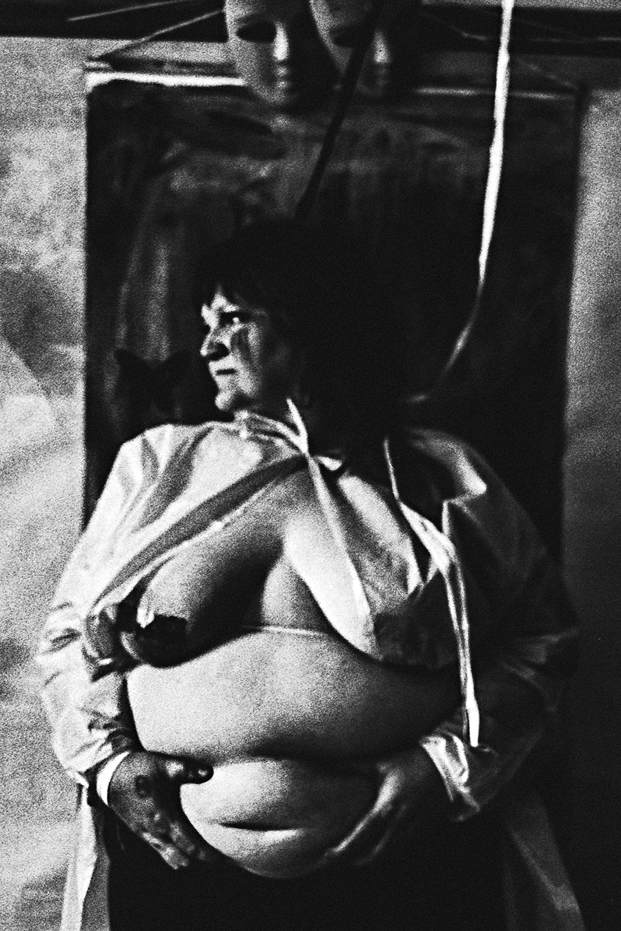 analoge fotokunst leipzig, dicke frau steht vor einem dunklen hintergrund, sie schaut zur seite