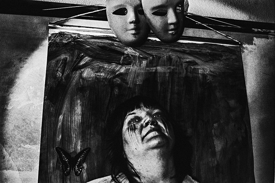 analoge fotokunst leipzig, Analogfoto auf Fomapan 400 Ortho, um eine Stufe gepusht, stark körnig. Eine dicke Frau steht frontal, der breite Oberkörper teilweise freigelegt. Ihr Gesicht ist vollständig mit einer glänzenden hellen Substanz bedeckt und dadurch unkenntlich. keine ohne sichtbare Maske.