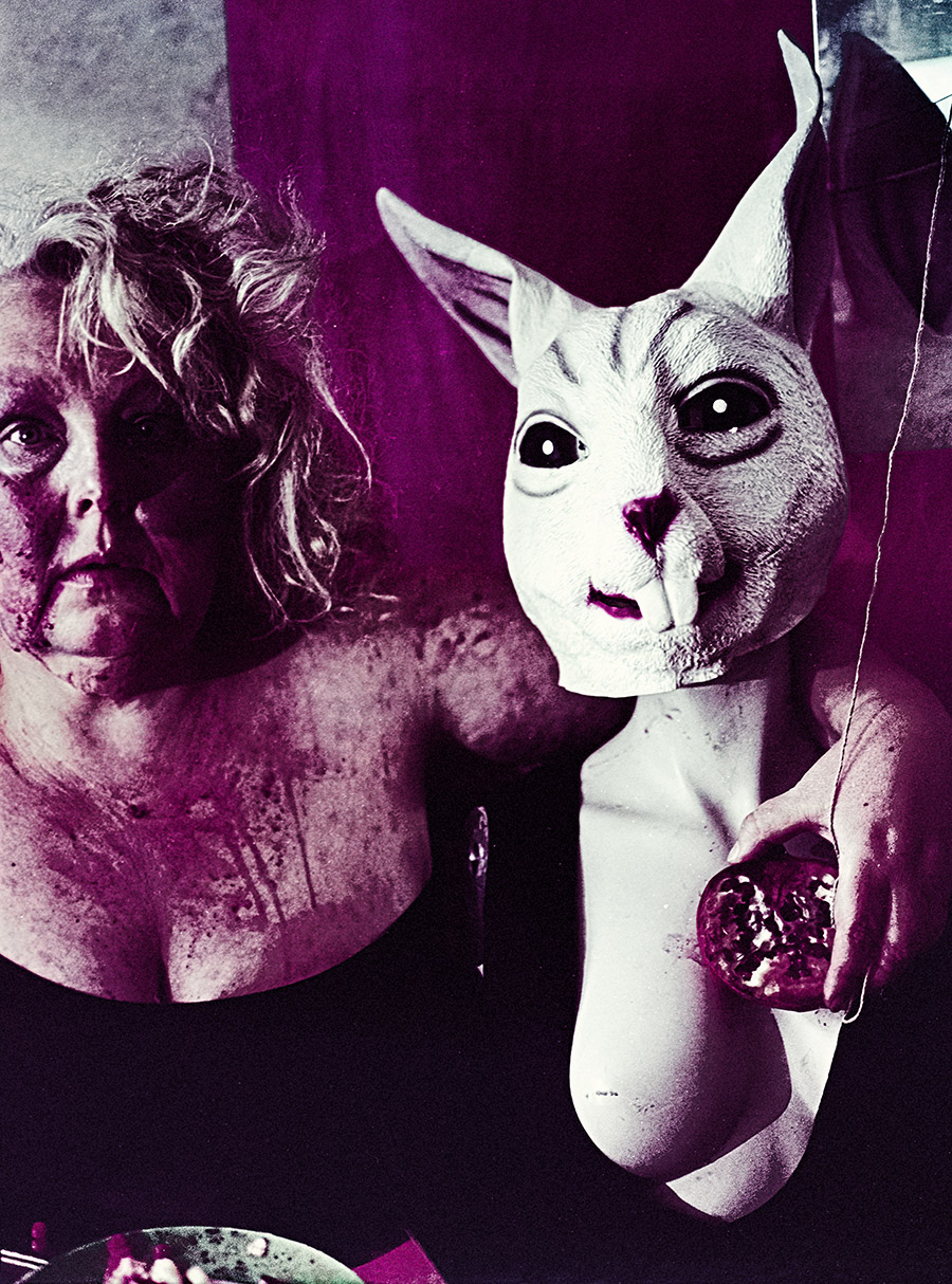 Frau mit erschöpftem Blick neben Häschenmaske die einen Granatapfel hält, Granatapfelsaft-Spuren auf der Haut, dunkle Magenta-Töne durch Kodak Color 200 Filmsuppe — Antje Kröger analoge Fotografie Leipzig, Serie Tischgesellschaft