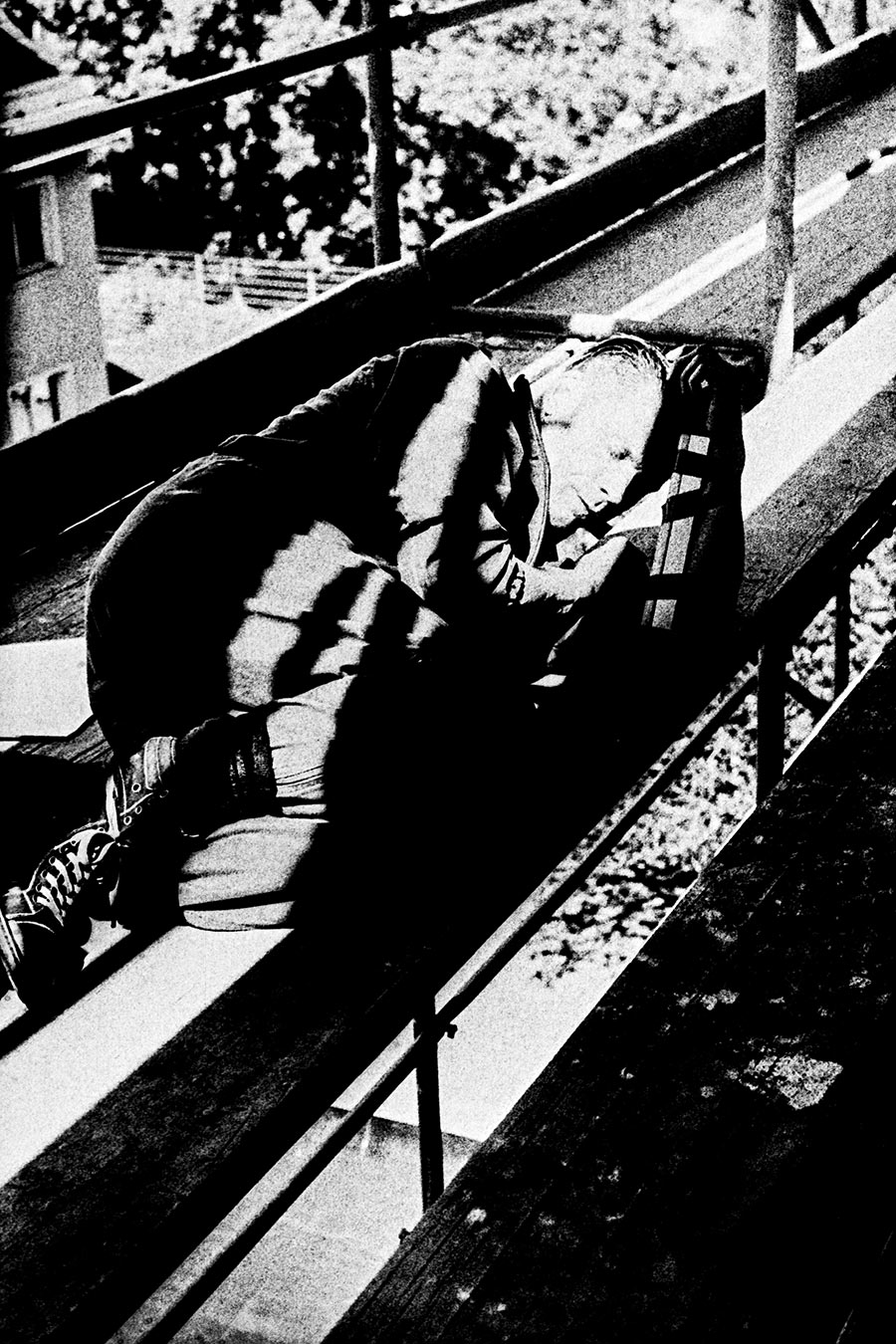 Zenith analog, inszeniertes Schwarzweißfoto, Mann liegt auf Gerüstbohlen, hartes Licht, starkes Korn, emotionale Fotografie, gepushter Film
