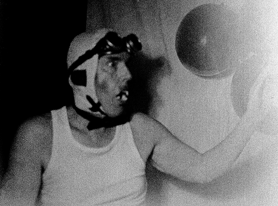 Analoges Mittelformat-Porträt: Mann mit Schweißerbrille und Vampirzähnen, Mund geöffnet, aggressiver Ausdruck, hartes Schwarzweiß, Mamiya, Antje Kröger
