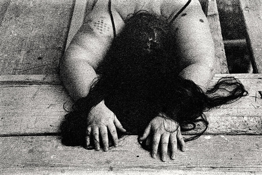 Kniende Frau auf Gerüstboden, Hände flach auf Holz, Haar verdeckt Gesicht, dicker Körper frontal, 35mm-Kleinbild – analoge Körperfotografie Antje Kröger Leipzig, Serie Walsturz