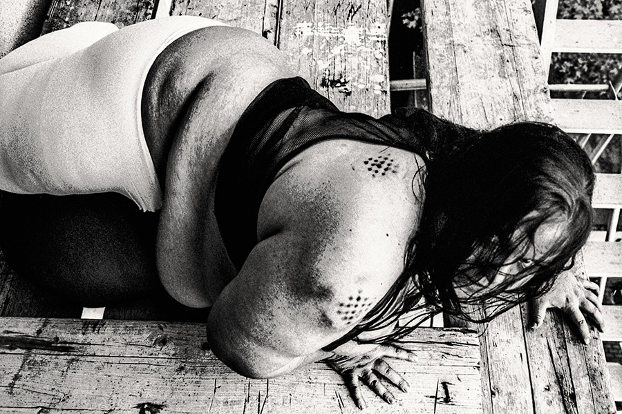Dicker Rücken auf Gerüstboden, Körper zusammengesunken, Hände flach auf Holz, Haar ausgebreitet, 35mm-Schwarzweiß – Antje Kröger Körperfotografie Leipzig Berlin, Serie Walsturz
