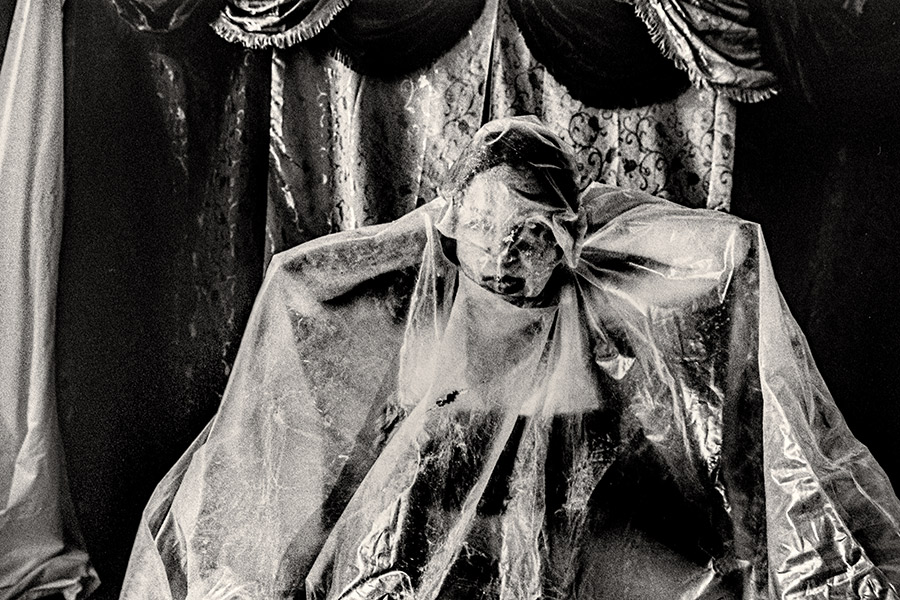 Frau mit transparenter Folie eng um Kopf und Oberkörper gebunden, analoges Schwarzweißfoto Fomapan Ortho 400 gepusht, Membran. Ich.