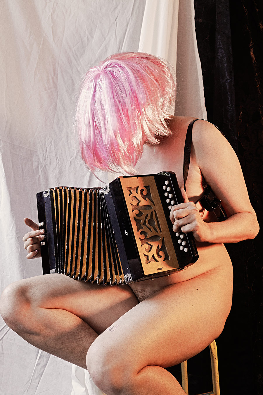 Aktfotografie nackte Frau pinke Perücke Akkordeon Hocker Gesicht verdeckt Kunstfotografie Leipzig