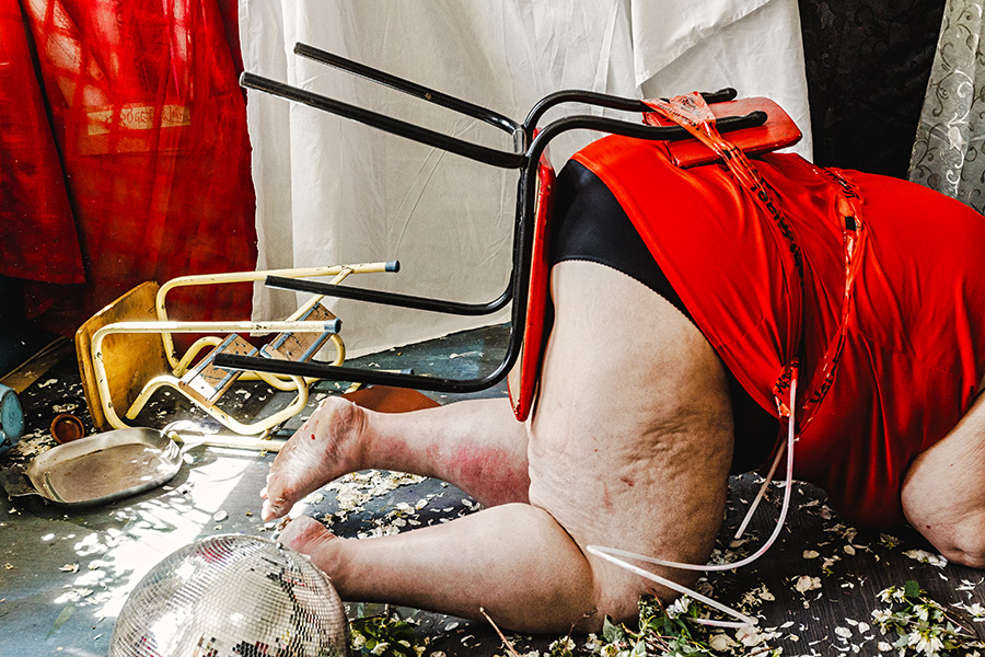 Fotokunst Körper am Boden Discokugel Blütenblätter Stuhl Performance Chaos Körperkunst