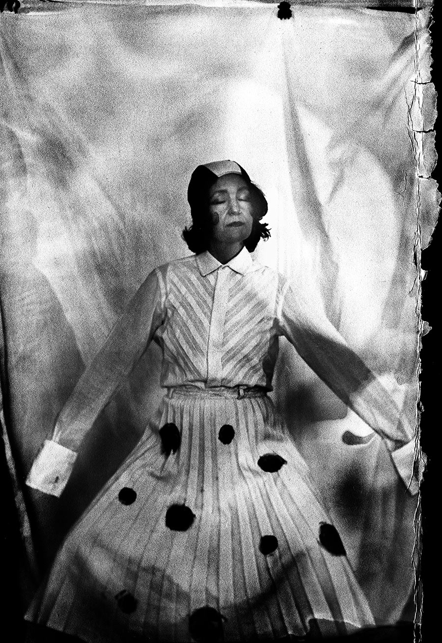 Analoges Portrait auf Fotopapier ORWO, Frau mit geschlossenen Augen und ausgebreiteten Armen, Bluse und gepunkteter Rock, Licht von oben, Kamera Mentor, Serie Meeresschnee, Antje Kröger