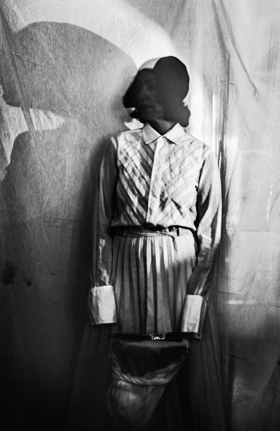 Analoges Portrait auf Fotopapier ORWO, stehende Frau in Bluse und Rock, Kopf durch Überbelichtung geschwärzt, großer Schatten, Kamera Mentor, Serie Meeresschnee, Antje Kröger