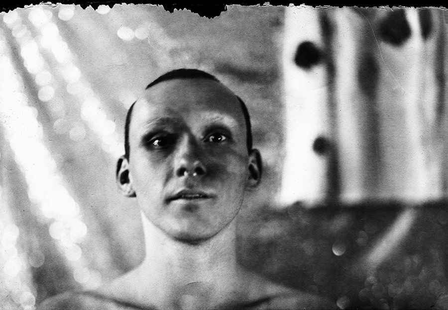 Frontales Kopfporträt, Kamera Mentor, ORWO Fotopapier, ausgefranster Bildrand, weicher Hintergrund mit Lichtreflexen, analoge Schwarzweißfotografie Meeresschnee 3