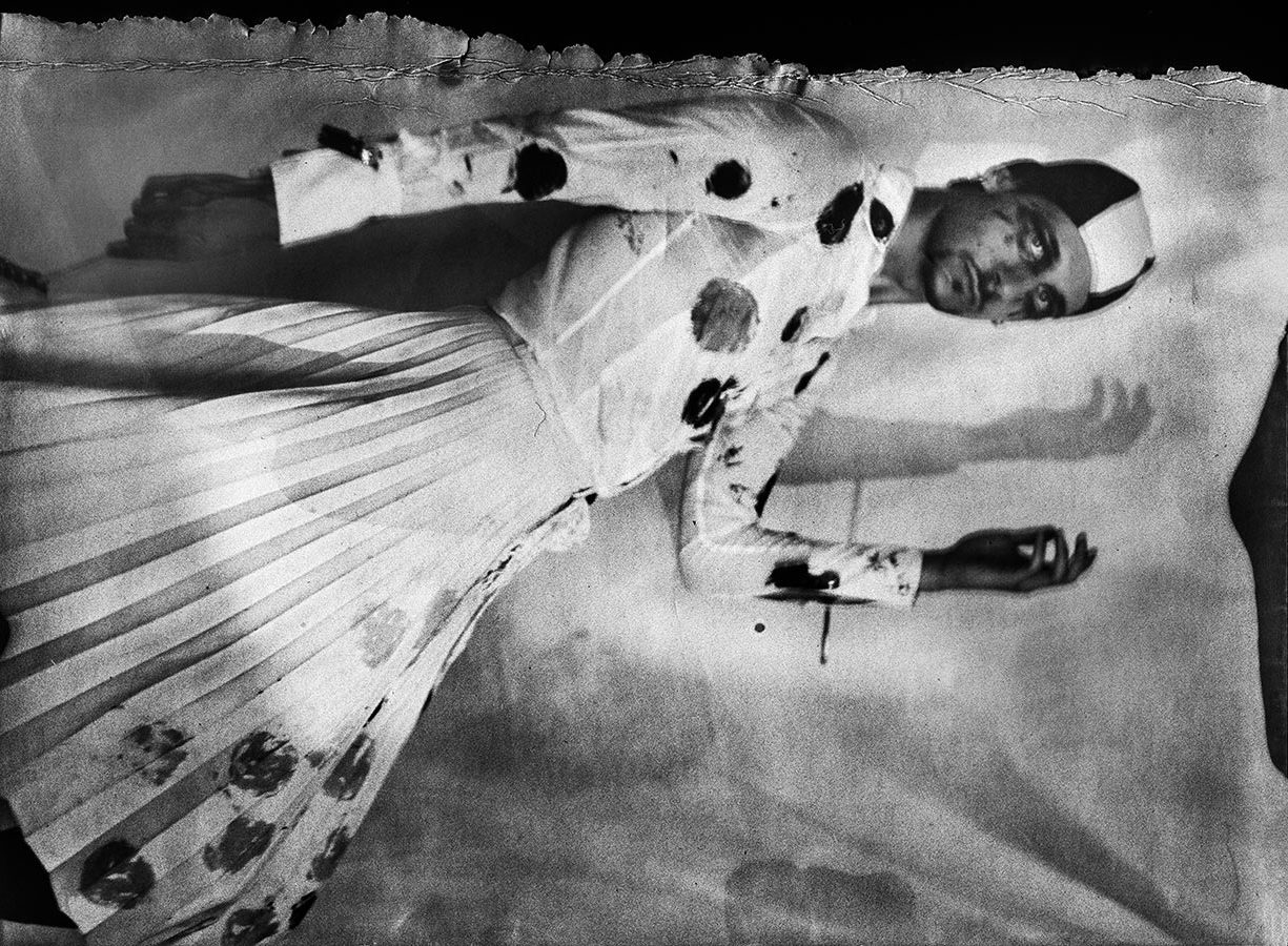 Seitliches Ganzkörperporträt mit erhobenem Arm, Badekappe, gepunkteter Faltenrock, Schattenwurf an der Wand, Kamera Mentor, ORWO Fotopapier, analoge Fotografie Meeresschnee 4