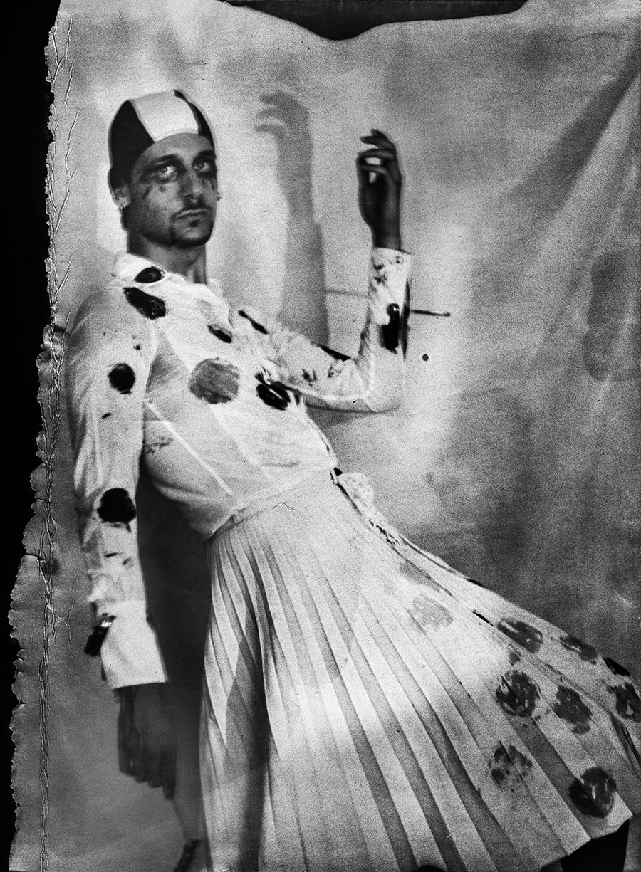 Seitliches Ganzkörperporträt mit erhobenem Arm, Badekappe, gepunkteter Faltenrock, Schattenwurf an der Wand, Kamera Mentor, ORWO Fotopapier, analoge Fotografie Meeresschnee 4