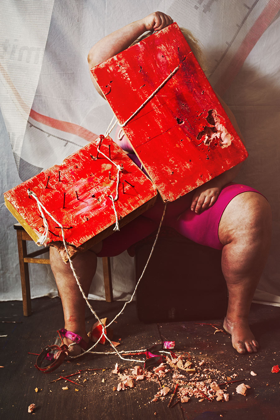 Verstecktes Gesicht hinter zwei roten Holzbrettern mit Nägeln, gefesselte Füße mit pinken Sandalen, Canon 6D, Bondage-Fotografie Vogelfrei