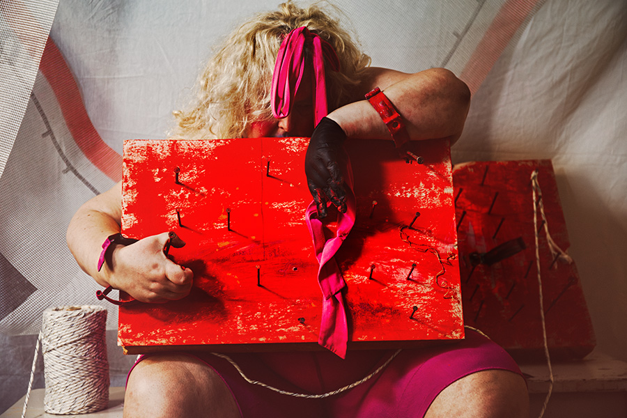 Verdecktes Gesicht mit pinkem Stirnband über rotem Nagelbrett, gefesselte Handgelenke mit rotem Riemen, Canon 6D, Bondage-Fotokunst gefesselte Freiheit