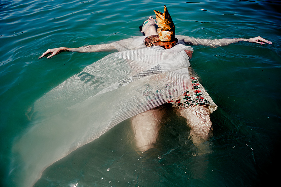 körper von oben treibend im wasser mit fischmaske am hals, netzstoff bedeckt beine, fine-art-fotografie fischtanz-serie, canon 6d