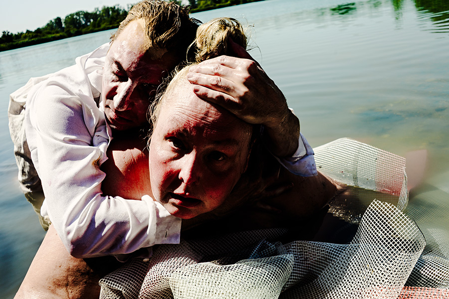 tänzer hält kopf der dicken frau fest, beide im wasser, spannungsgeladenes duo schwanensee teil 2, pentacon-objektiv
