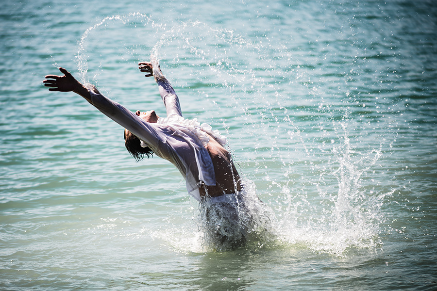 tänzer wirft sich rückwärts ins wasser, arme weit ausgebreitet, dramatische bewegungsfotografie schwanensee teil 3
