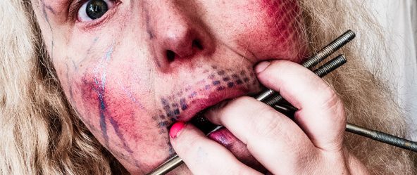 extreme nahaufnahme gesicht mit nägeln im mund, bemalte haut mit gitterlinien, expressives selbstporträt stanze-serie