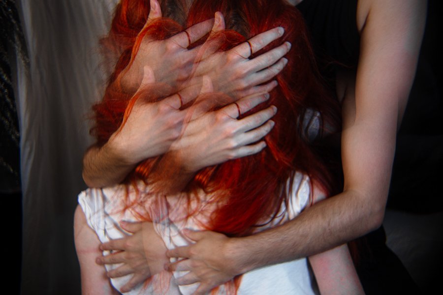 Nahaufnahme mehrerer ineinander verschlungener Hände im roten Haar, Mehrfachbelichtung, dunkler Bildausschnitt, konzeptuelle Fotografie zum Thema Tod und Vergänglichkeit