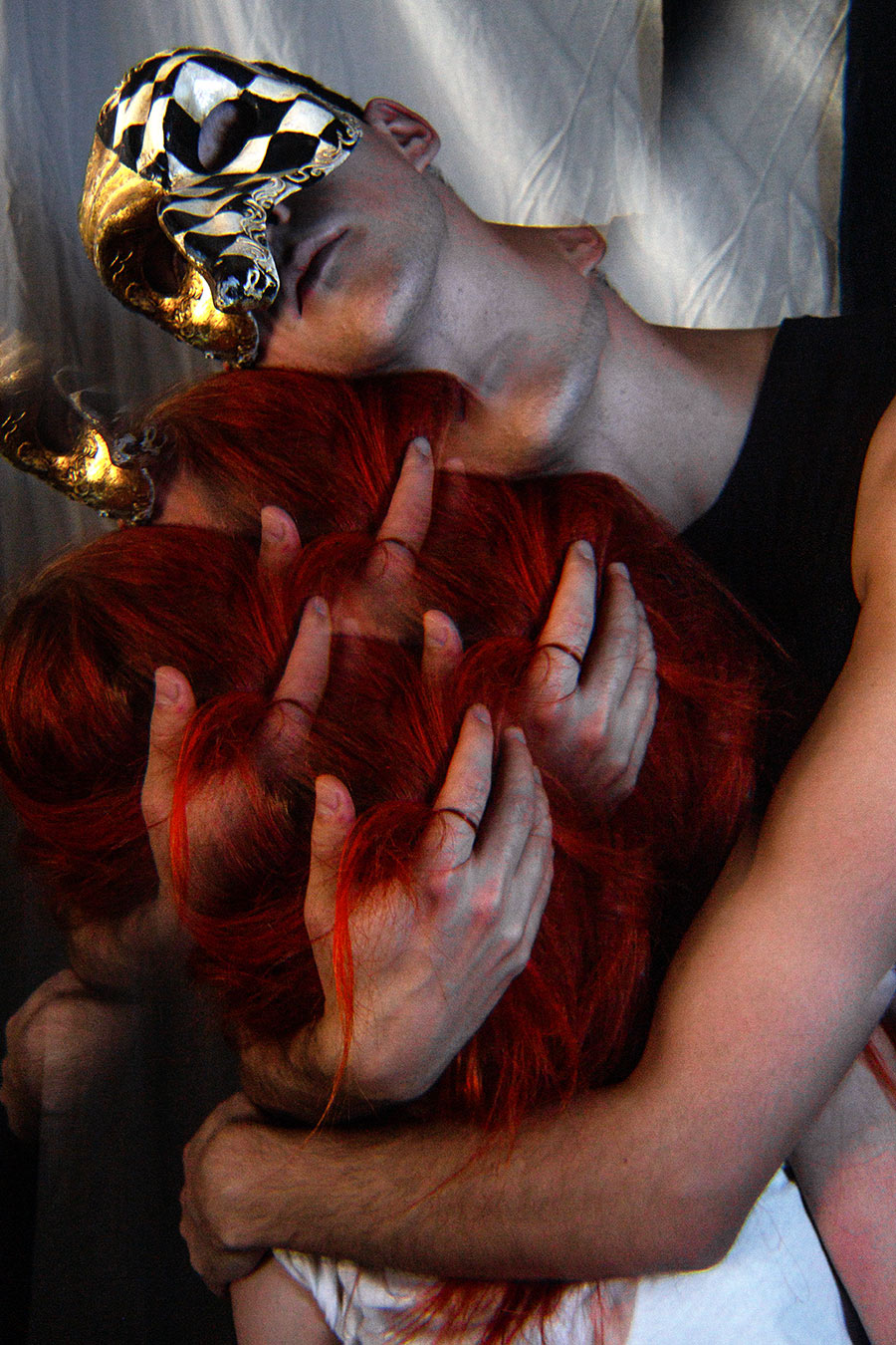 Kopf mit venezianischer Maske im Nacken zurückgelehnt, mehrere Hände greifen ineinander verschlungen in rotes Haar, Mehrfachbelichtung, inszenierte Tod-Fotografie, analog-digitale Technik