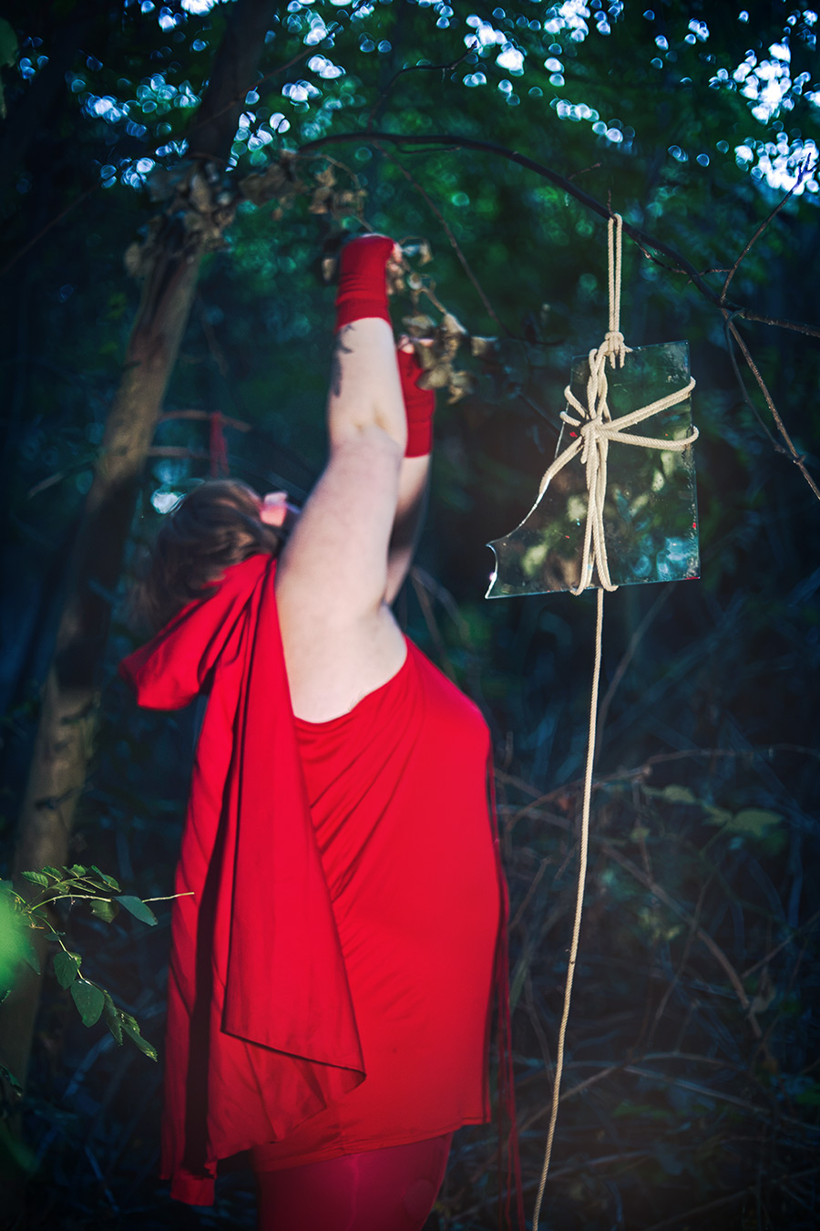 rotkäppchen arm gestreckt zerbrochener spiegel baum, rotes cape rückenansicht, inszenierte fotografie piroska