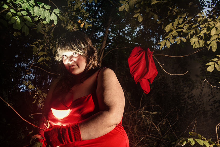 rotkäppchen taschenlampe beleuchtet brust, cape hängt im baum hintergrund, wald, fotografie piroska